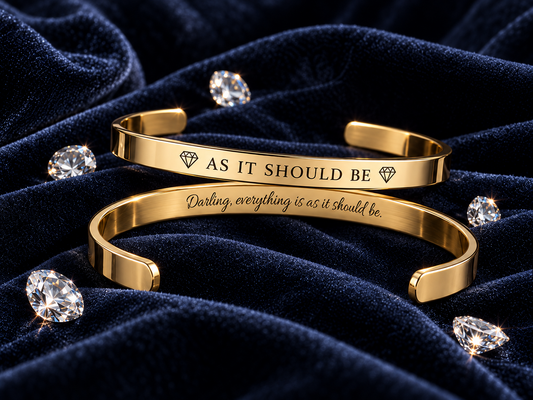 Gold cuff bracelet engraved AS IT SHOULD BE with hidden inside message, on navy velvet